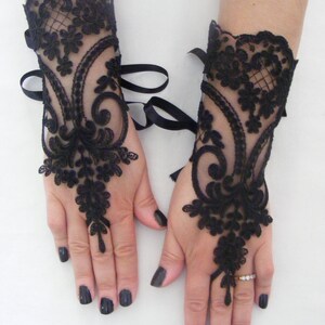 May include: A pair of black lace fingerless gloves with ribbon ties at the wrist.