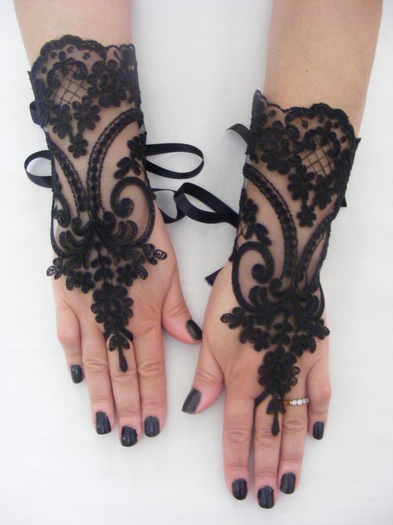 May include: A pair of black lace fingerless gloves with ribbon ties at the wrist.
