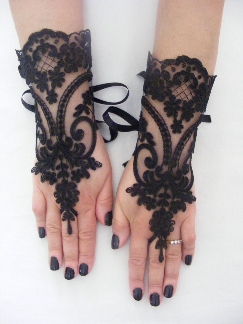 May include: A pair of black lace fingerless gloves with ribbon ties at the wrist.