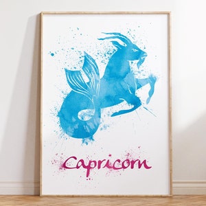 May include: A framed art print featuring a blue watercolor illustration of the Capricorn zodiac sign. The image depicts a goat with a fish tail, with the word "Capricorn" in pink script below. The artwork is displayed on a white background.
