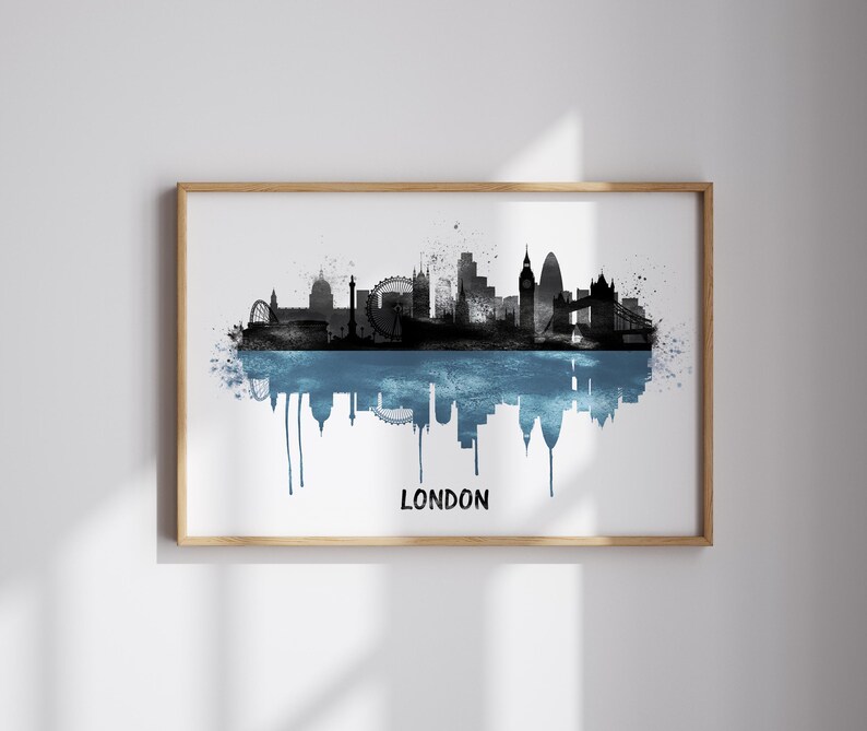 May include: A framed print featuring a black and blue watercolor depiction of the London skyline. The artwork includes iconic landmarks like the London Eye and Big Ben, with the word "LONDON" in white at the bottom.