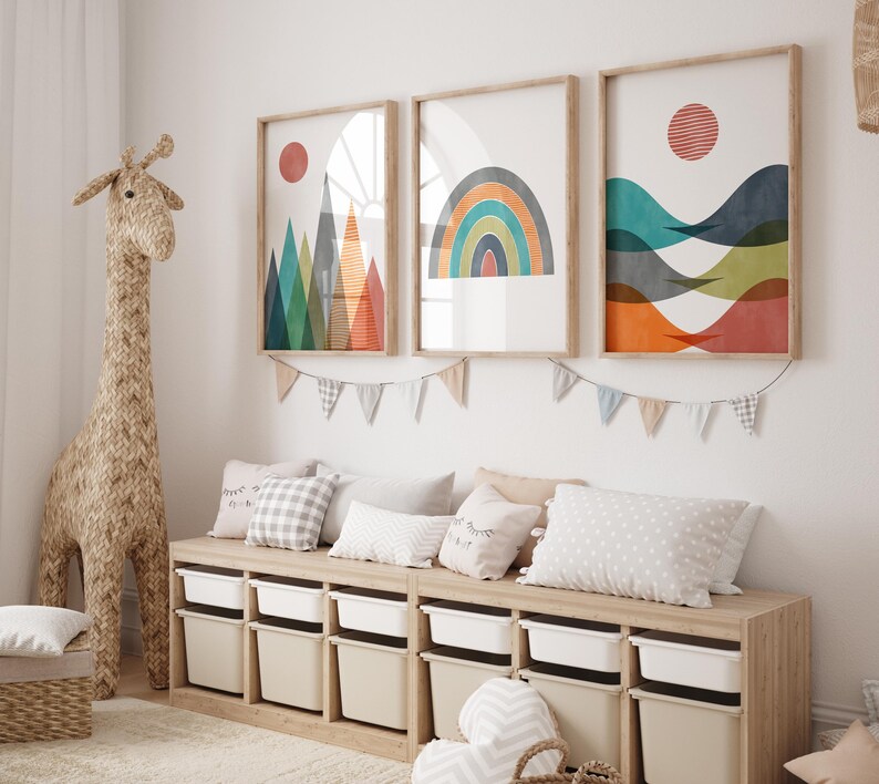 May include: A wooden storage bench with six white bins, featuring a giraffe toy and three framed abstract art prints with geometric shapes and colours, including a rainbow, mountains, and waves.