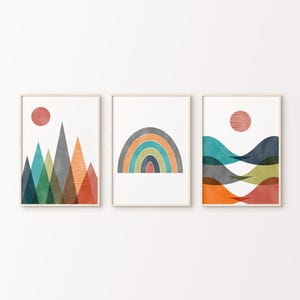 May include: Set of three abstract art prints featuring geometric shapes in shades of blue, green, orange, and red. The prints depict a mountain range, a rainbow arch, and a series of wavy lines.