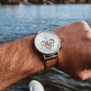 Reloj de lujo para hombre con cristal de zafiro, cronógrafo, detalles de madera y texto personalizado.
