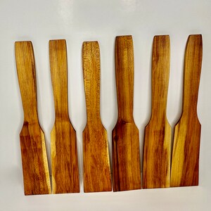 Image of six handmade maple woodcooking spatulas with varying woodgrain.