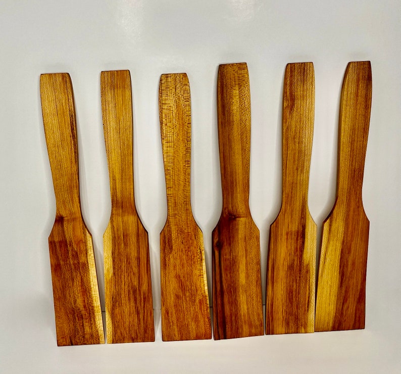 Image of six handmade maple woodcooking spatulas with varying woodgrain.