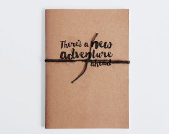 Travel Journal with a fun quote "There's a new Adventure ahead".  Hand finished notebook with a Recycled Card cover. Eco Friendly journal.