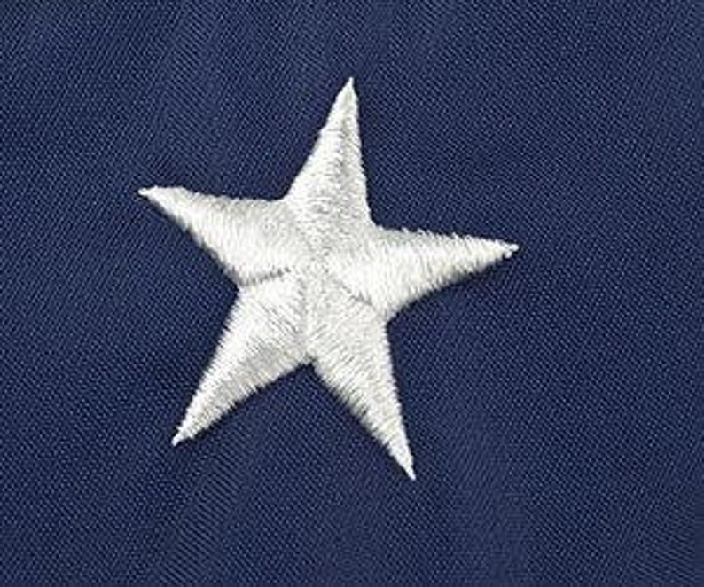 May include: A white embroidered star on a navy blue background.