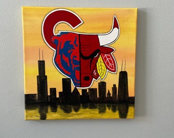 May include: A painting of a Chicago skyline with a red bull and a blue bear head superimposed over the city. The bull and bear are split down the middle, with the bull on the right and the bear on the left. The bull has a red and white color scheme, while the bear has a blue and red color scheme. The skyline is silhouetted against a yellow sunset.