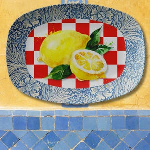 May include: Oval serving platter with a watercolor lemon design. The center features a red and white checkered pattern with a whole lemon and a lemon half. The border has a blue and white floral design.