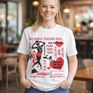 May include: White t-shirt with a dance-themed graphic. The design features a silhouette of a dancer in a hat and a red outfit, along with text that reads "MY DANCE TEACHER SAYS..." and dance instructions. The shirt is worn by a person.