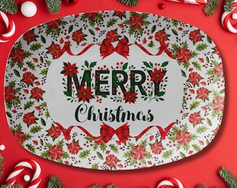 May include: Oval serving platter with a festive Christmas design. The platter features a white background with red poinsettias, green holly, and red ribbons. The words "MERRY Christmas" are in the centre.
