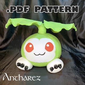 May include: A plush toy in the shape of a green creature with large, leaf-like ears and white accents. The toy has red eyes and black claws. The text ".PDF PATTERN" is at the top, and "Antharez" is at the bottom.