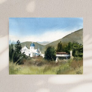 Puede incluir: Pintura acuarela de una iglesia blanca con una cúpula azul, rodeada de árboles verdes y colinas. La iglesia se encuentra en un cielo azul con nubes blancas. La pintura está firmada "R.S.C. 2014" en la esquina inferior derecha.