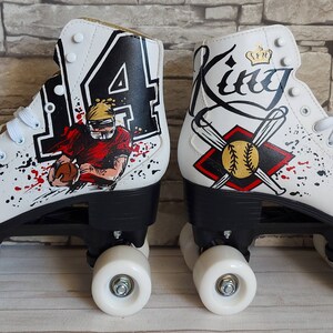 May include: A pair of white roller skates with custom painted designs. One skate features a football player with the number "14" and the other skate features a baseball with bats and the word "King".