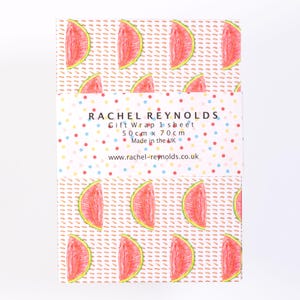 May include: A sheet of gift wrap featuring a repeating pattern of watermelon slices on a dotted background. The gift wrap is labeled "RACHEL REYNOLDS Gift Wrap 1 sheet" and measures 19.6 inches x 27.5 inches. The gift wrap is made in the UK.