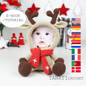 Può includere: Cornice per foto a forma di renna all'uncinetto con una sciarpa rossa e fiocchi di neve bianchi. La cornice è beige e marrone e ha uno spazio per una foto. Il testo "E-BOOK / TUTORIAL" è visibile nell'immagine. L'immagine include anche bandiere per gli Stati Uniti, la Germania, la Russia, la Spagna, l'Unione Europea, l'Italia, la Francia, il Portogallo e la Danimarca.