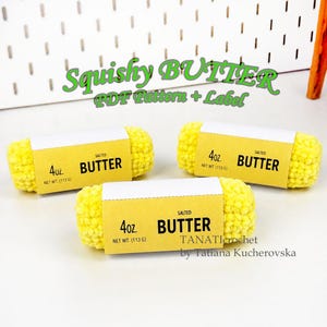 Może przedstawiać: Trzy żółte szydełkowane kostki masła z białymi papierowymi etykietami. Każda etykieta zawiera napis 4oz. NET WT. (113 G) SALTED BUTTER. Widoczny jest tekst Squishy BUTTER PDF Pattern + Label oraz TANATIcrochet by Tatiana Kucherovska.