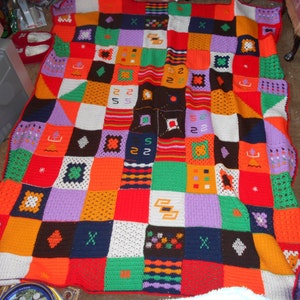 May include: A colourful crocheted blanket with a patchwork design. The blanket is made up of squares in various colours, including red, orange, yellow, green, blue, purple, and white.