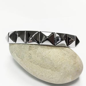 Armband i rostfritt stål med pyramidknappar • 80-tals punkstil
