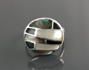 May include: A silver ring with a round, black and white abalone shell inlay.