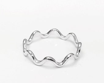 May include: A silver ring with a wavy design.