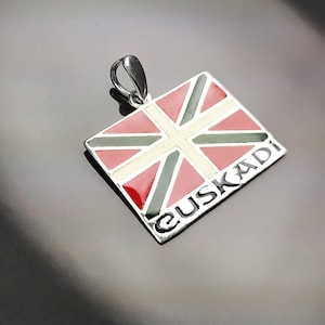 Puede incluir: Pendiente de plata con una bandera de esmalte rojo, blanco y verde con la palabra "EUSKADI" inscrita en ella.