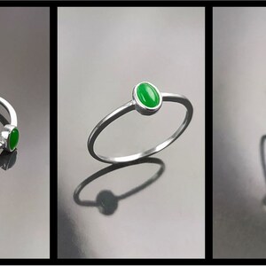 May include: A silver ring with a green oval-shaped gemstone. The ring is shown from three different angles.