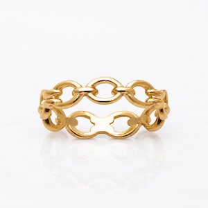 Op de afbeelding: Een gouden ring met een doorlopend schakelontwerp. De band bestaat uit onderling verbonden, ovaalvormige metalen schakels met een gepolijst, reflecterend oppervlak. De ring heeft een uniforme goudkleur over de gehele structuur.