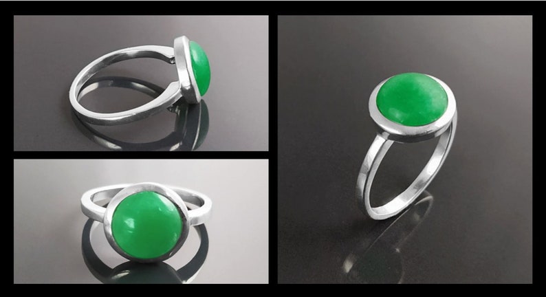 May include: A silver ring featuring a large, round, bright green stone. The stone is set in a bezel setting, and the band is a simple, polished silver. The ring is displayed in multiple views against a dark background.