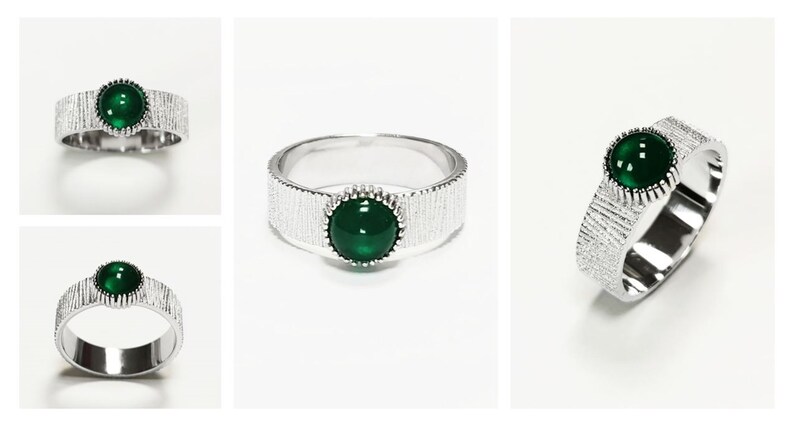 Puede incluir: Un anillo de plata con una banda texturizada y una piedra preciosa verde engastada en un engaste de plata.