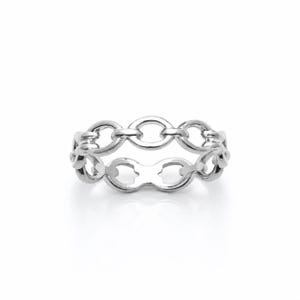 May include: A polished silver-tone ring featuring a continuous band design composed of interconnected oval links. The metal has a smooth, reflective surface that catches the light, creating a uniform metallic appearance throughout the entire piece.