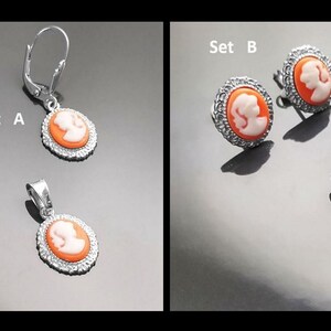 May include: Two sets of jewelry featuring cameo pendants and earrings. Set A includes a pendant and dangle earrings. Set B includes a pendant and stud earrings. All pieces feature a white cameo profile on a peach background.