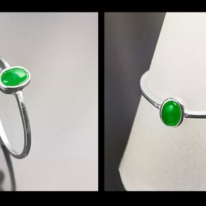 May include: A silver ring with a bright green oval gemstone.