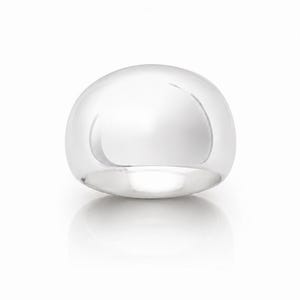 May include: A polished silver-tone dome ring with a smooth, reflective surface. The ring features a wide, rounded band design that creates a continuous, seamless curve. The metal has a high-shine finish that catches the light, highlighting the rounded shape of the piece.
