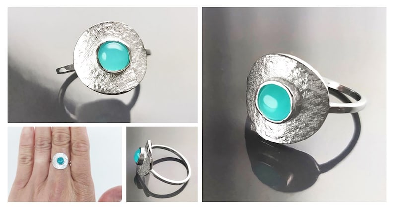 May include: A silver ring with a textured, circular band and a turquoise gemstone set in the center.