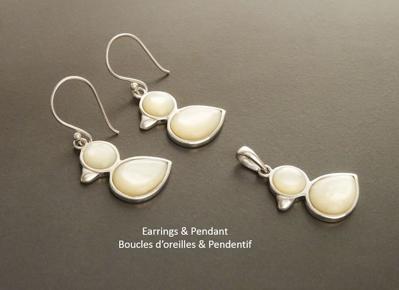 Puede incluir: Un juego de pendientes de plata y un colgante con un dise&ntilde;o de pato con detalles de n&aacute;car blanco. Pendientes & Colgante, Boucles d'oreilles & Pendentif.