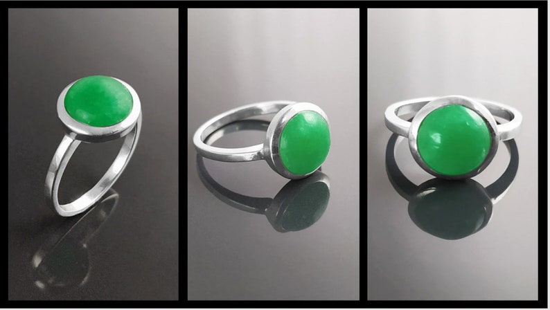 May include: A sterling silver ring with a bright green, round gemstone. The gemstone is set in a bezel setting, and the ring has a simple, elegant design. The ring is displayed in three different views.