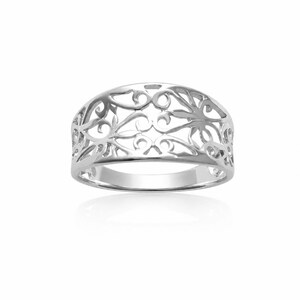 Può includere: Un anello color argento caratterizzato da un intricato design in filigrana traforata che avvolge la fascia. La superficie metallica è lucida e riflettente, mostrando una serie di motivi interconnessi, curvi e vorticosi lungo tutta la fascia.