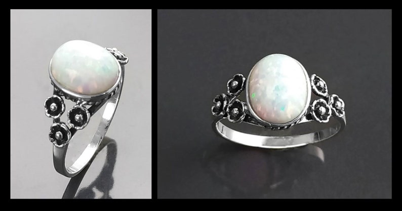 Puede incluir: Anillo de plata con una gran piedra de &oacute;palo ovalada. El &oacute;palo tiene un aspecto blanco lechoso con destellos iridiscentes. El anillo est&aacute; adornado con peque&ntilde;os detalles florales oscuros en los laterales, a&ntilde;adiendo un toque delicado a la joya.