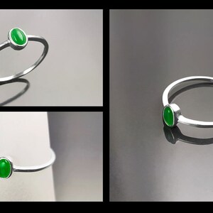 May include: A silver ring with a green oval-shaped gemstone.
