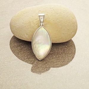 May include: A marquise-shaped pendant featuring an iridescent mother-of-pearl inlay set within a polished silver-toned metal frame. The pendant includes a tapered silver-toned bail at the top for attachment to a chain or cord necklace.