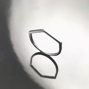 Peut inclure: Une bague en argent de forme hexagonale géométrique. La bague est simple et de design moderne.