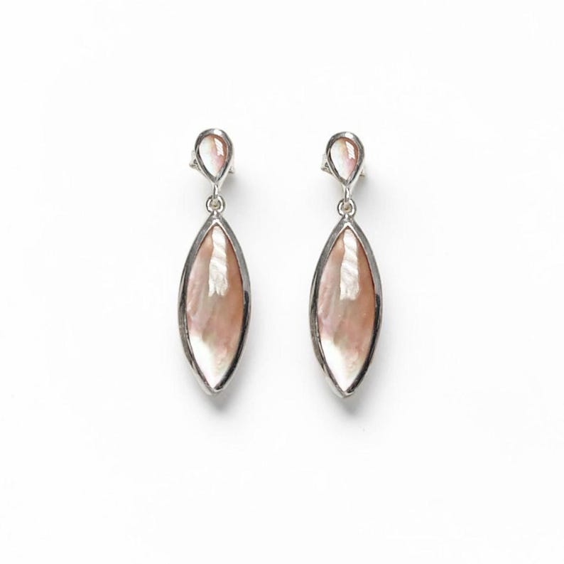May include: A pair of drop earrings featuring marquise-shaped iridescent shell inlays set in polished silver-tone metal. Each earring consists of a small teardrop-shaped top piece connected to a larger, elongated marquise-shaped bottom section.