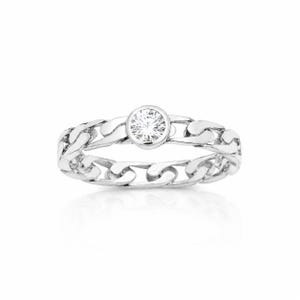 Op de afbeelding: Een zilverkleurige ring met een schakelbandontwerp en een enkele ronde, heldere, gefacetteerde steen in een ronde zetting in het midden. Het metaal heeft een gepolijste, reflecterende afwerking, wat zorgt voor een heldere en metalen uitstraling.