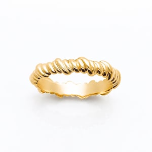 May include: A polished gold ring featuring a continuous twisted rope texture around the entire band. The metal has a bright, reflective finish with a uniform yellow gold tone, creating a circular shape with a smooth interior surface.