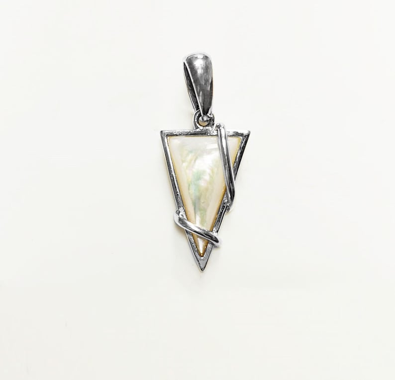 May include: A triangular pendant featuring a polished silver-tone metal frame with a smooth, iridescent mother-of-pearl inlay. A slender silver-tone metal wire wraps diagonally across the front of the triangle, connecting to a top bail loop.