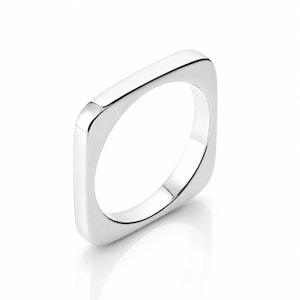 Könnte beinhalten: Ein polierter silberfarbener Ring mit einem markanten quadratischen Band und abgerundeten Ecken. Die Metalloberfläche ist glatt und reflektierend und weist eine durchgehend gleichmäßige Dicke entlang des gesamten quadratischen Umfangs auf.