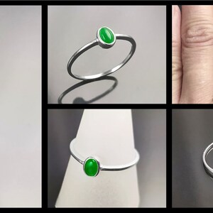 May include: A silver ring with a green oval gemstone. The ring is simple and delicate, and the gemstone is set in a bezel setting.