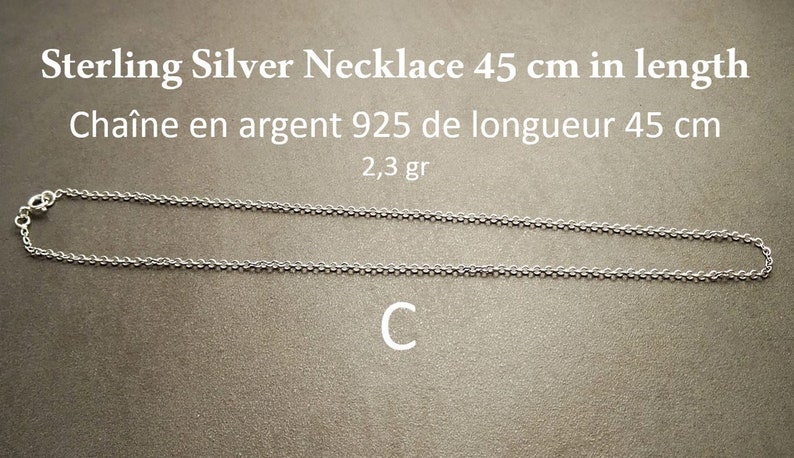 May include: A silver chain necklace, 45 inches long, made of 925 sterling silver. The necklace weighs 2.3 grams. The text "Sterling Silver Necklace 45 cm in length" and "Cha&icirc;ne en argent 925 de longueur 45 cm" is visible in the image.